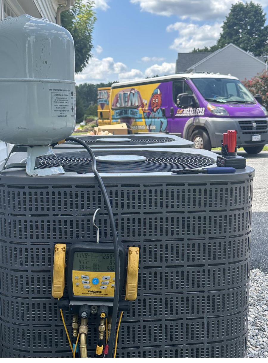 Technician's gauges connected to an outdoor condensing unit during a tune-up
