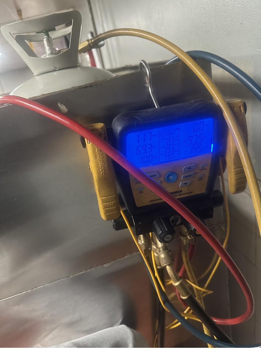 Refrigerant manifold gauges connected during a charge check