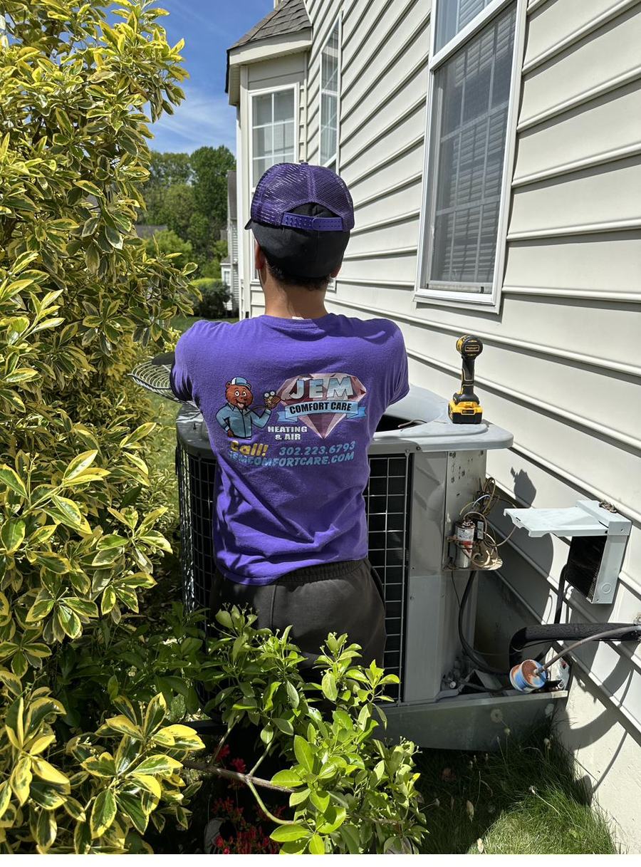 JEM technician installing a mini-split condenser at a home