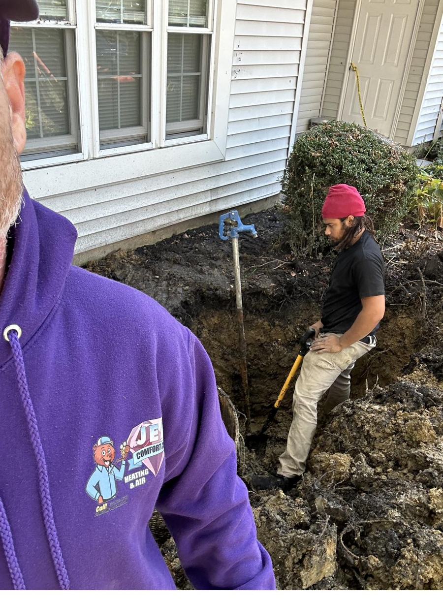 Crew running a new line set and trenching outside a home