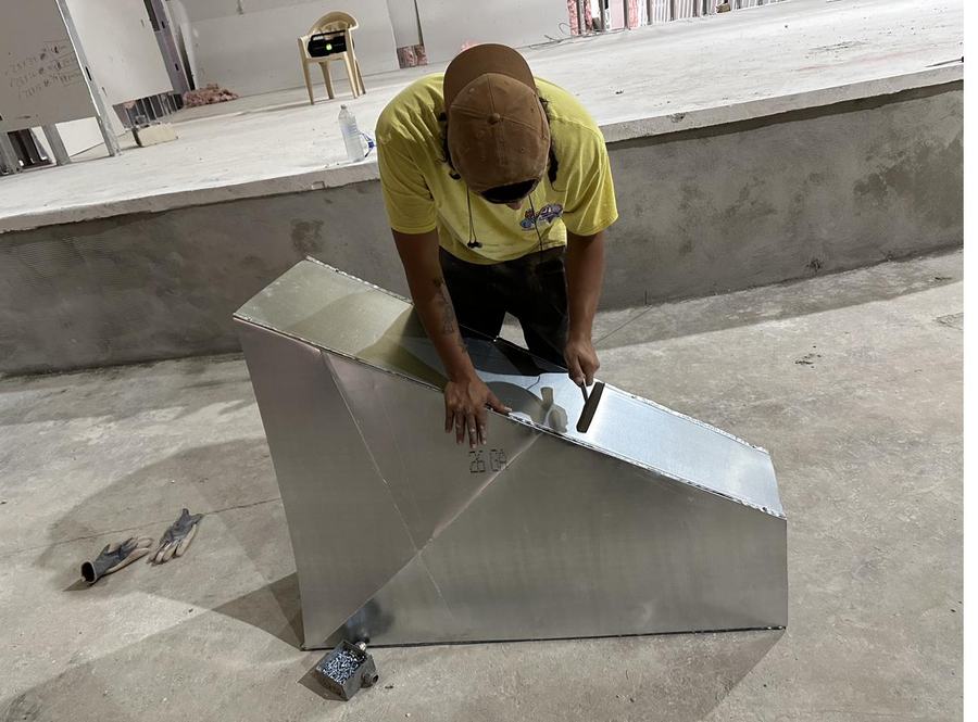 Technician fabricating a custom sheet metal plenum on site