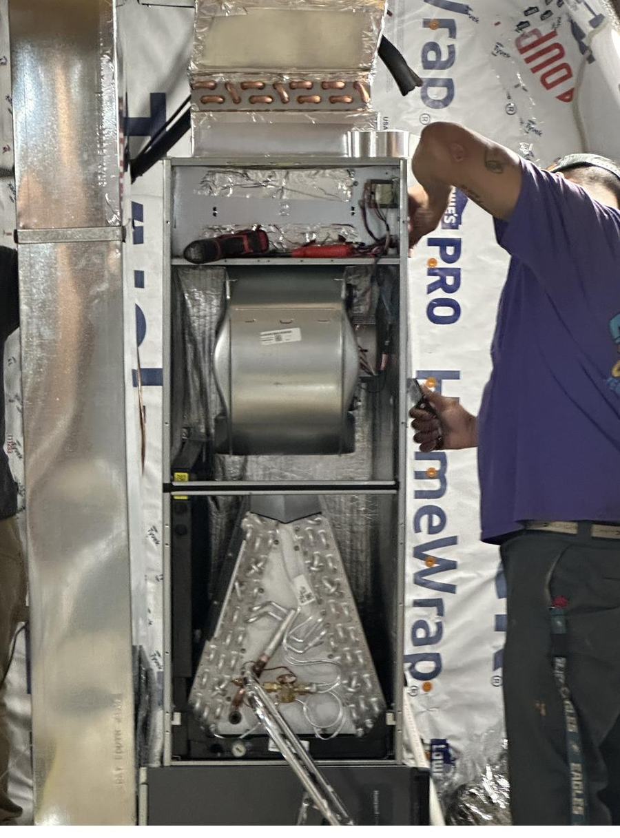JEM technician servicing an air handler during an install